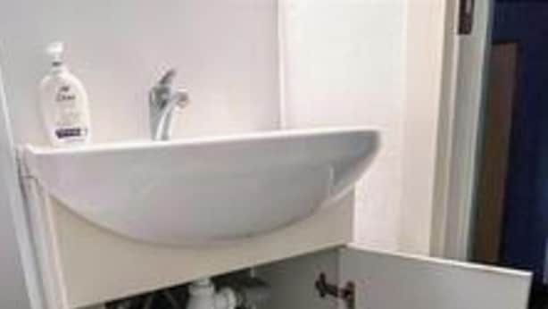 A bathroom with a white sink, a mirror, and a bottle of hand soap. - 4 Person Holiday Home in Aeroskobing (Aeroskobing)