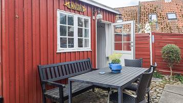 Un bâtiment rouge avec une enseigne sur laquelle on peut lire « MAGDA » et une table entourée de chaises à l’extérieur.