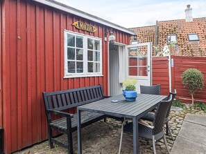 A red building with a sign reading 'MAGDA' and a table with chairs outside. - 4 Person Holiday Home in Aeroskobing (Aeroskobing)