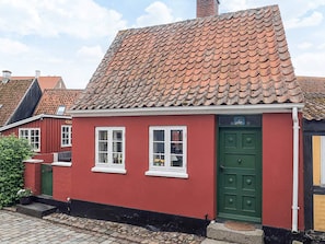 A red building with a green door and white windows, featuring a traditional tiled roof. - 4 Person Holiday Home in Aeroskobing (Aeroskobing)