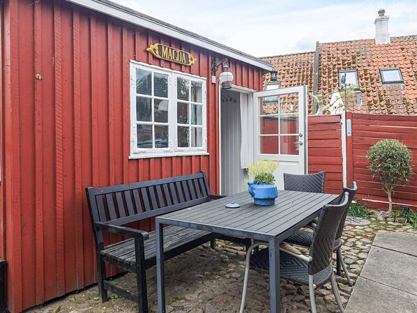 A red building with a sign 'MAGDA' and a table with chairs outside.