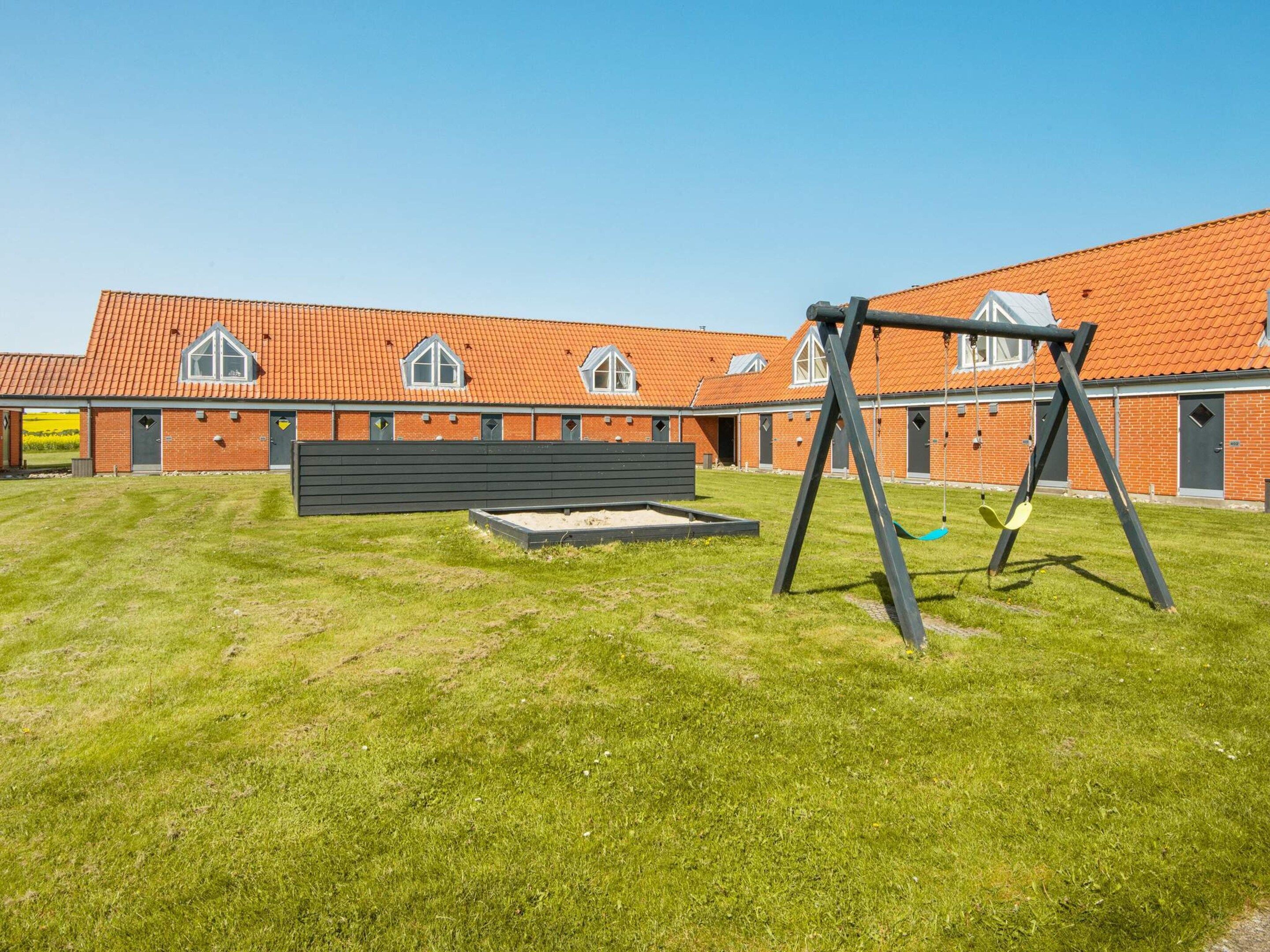 En bygning med røde tegltagsten og mange vinduer.
