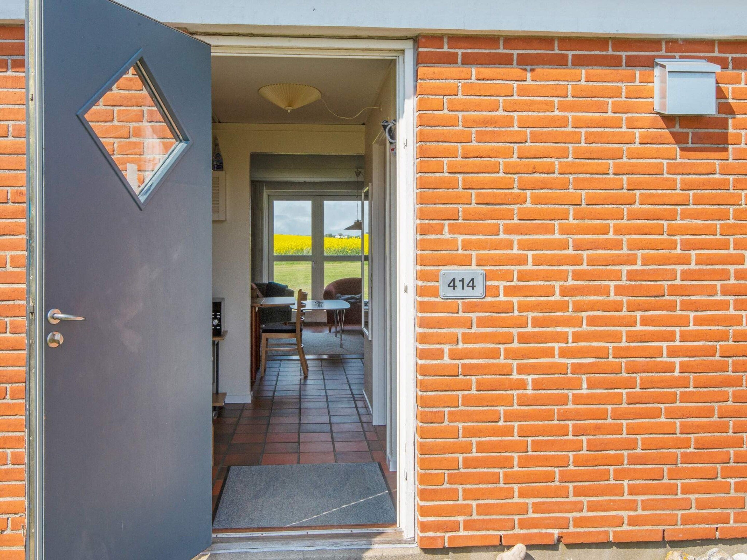 A door leading to a room with a tiled floor, a small table, and a chair.