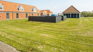 Un quartiere residenziale con un edificio in mattoni, una zona relax all'aperto coperta e un prato.