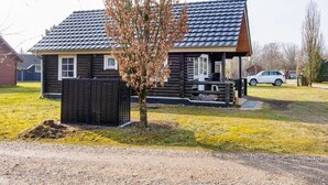 A log cabin with a sloped roof, a small porch, and a fenced yard. - 4 Person Holiday Home in Hovborg-by Traum (Hovborg)