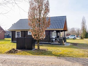 A log cabin with a sloped roof, a small porch, and a fenced yard. - 4 Person Holiday Home in Hovborg (Hovborg)