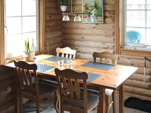 A wooden dining table with four chairs, two pendant lights, and a potted plant. - 4 Person Holiday Home in Hovborg (Hovborg)