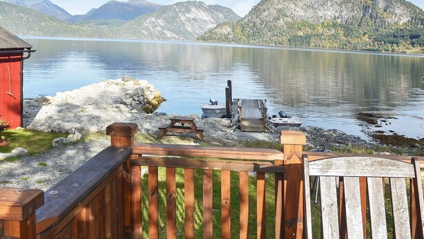 A wooden deck with a view of a lake and mountains. - Holiday Home in MÃ¥ndalen (Rauma)