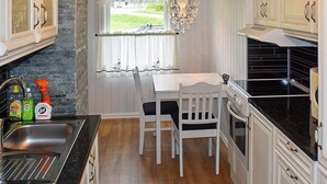 A kitchen with a dining table, chairs, a sink, and a stove. - Holiday Home in MÃ¥ndalen (Rauma)