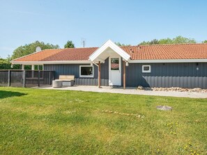 A single-story building with a red-tiled roof, a covered patio area, and a fenced yard. - 8 Person Holiday Home in Hejls-by Traum (Hejls)