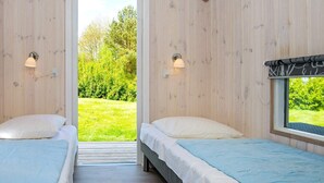 A room with two beds, wooden walls, and a view of greenery outside. - 8 Person Holiday Home in Hejls-by Traum (Hejls)