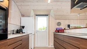 A modern kitchen with wooden cabinets, a refrigerator, a coffee machine, and a toaster. - 8 Person Holiday Home in Hejls-by Traum (Hejls)