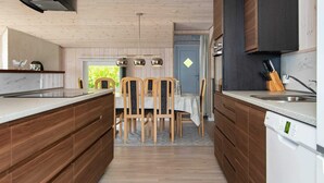 A modern kitchen with wooden cabinets, a central island, and pendant lighting. - 8 Person Holiday Home in Hejls-by Traum (Hejls)