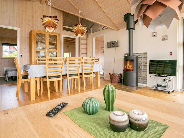 Una sala de estar acogedora con comedor de madera, chimenea y televisor.