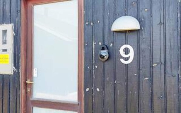 A wooden door with a glass panel and a number '9' sign. - 5 Star Holiday Home in Ulfborg (Ulfborg)