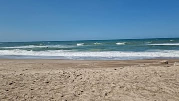 A sandy beach with waves in the background.