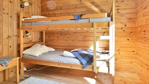 A bunk bed in a wooden cabin room with a small table and a lamp. - 8 Person Holiday Home in Lonsboda (Lönsboda)