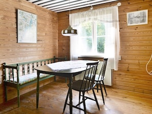 A wooden interior with a dining table, chairs, a bench, a hanging light fixture, and two framed pictures on the walls. - 8 Person Holiday Home in Lonsboda (Lönsboda)