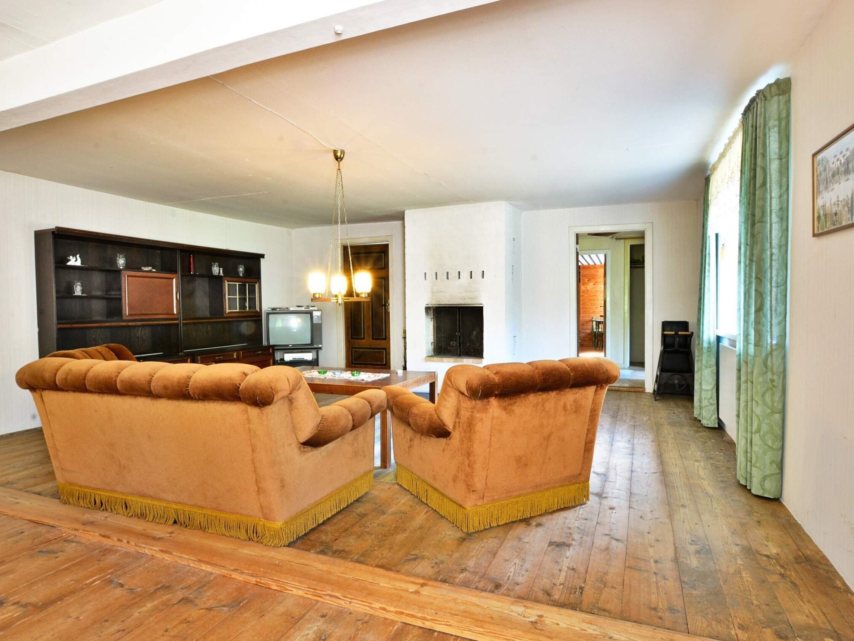 A spacious living room with a fireplace, a television, and a bookshelf.