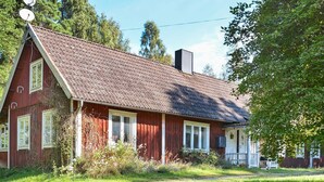 A red wooden house with a sloped roof, a satellite dish, and a chimney. - 8 Person Holiday Home in Lonsboda (Lönsboda)