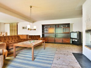 A living room with a brown sofa, a wooden coffee table, and a television. - 8 Person Holiday Home in Lonsboda (Lönsboda)