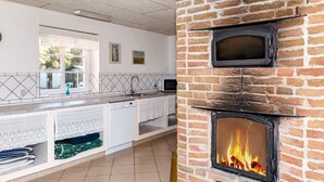 Une cuisine avec un mur en briques, un four encastré et une fenêtre.