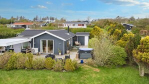 A modern house with a large deck, a covered outdoor seating area, and a small shed. - 6 Person Holiday Home in Struer-by Traum (Struer)