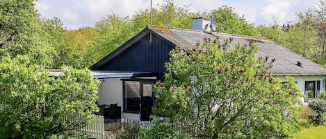 A house with a dark roof, a white exterior, and a visible satellite dish.