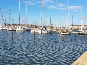 Un port de plaisance où de nombreux voiliers sont amarrés à des quais en bois.
