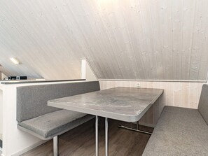 A modern, minimalist room with a built-in bench seating area, a flat-screen TV, and a power outlet on the wall. - Holiday Home in Wendtorf (Wendtorf)