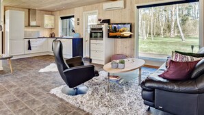 A modern interior with a kitchen, dining area, and a large window offering a view of the outdoors. - 2 Person Holiday Home in Laeso-by Traum (Læsø)