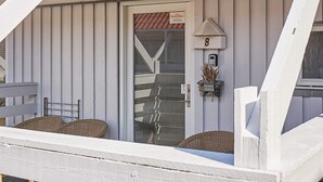 A building with a white exterior, a door with a DanCenter sign, and a mailbox. - Quaint Holiday Home in LÃ¸kken With Beach Nearby (Gudhjem)