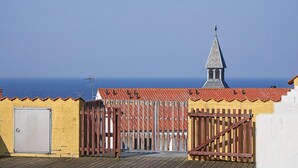 A coastal building with a red-tiled roof, a wooden fence, and a small tower-like structure. - Quaint Holiday Home in LÃ¸kken With Beach Nearby (Gudhjem)