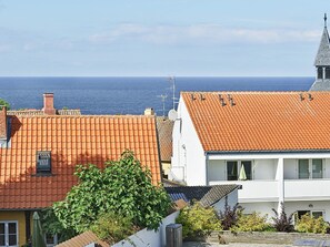 A coastal residential area with terracotta-tiled roofs, a white building with a balcony, and a clear view of the sea. - Quaint Holiday Home in LÃ¸kken With Beach Nearby (Gudhjem)