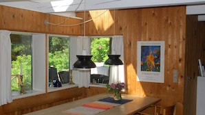 Una habitación con paneles de madera, una mesa grande, sillas y un cartel en la pared.
