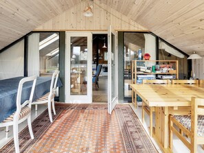 A cozy attic room with a dining table, chairs, and a bookshelf. - 7 Person Holiday Home in Fjerritslev-by Traum (Fjerritslev)