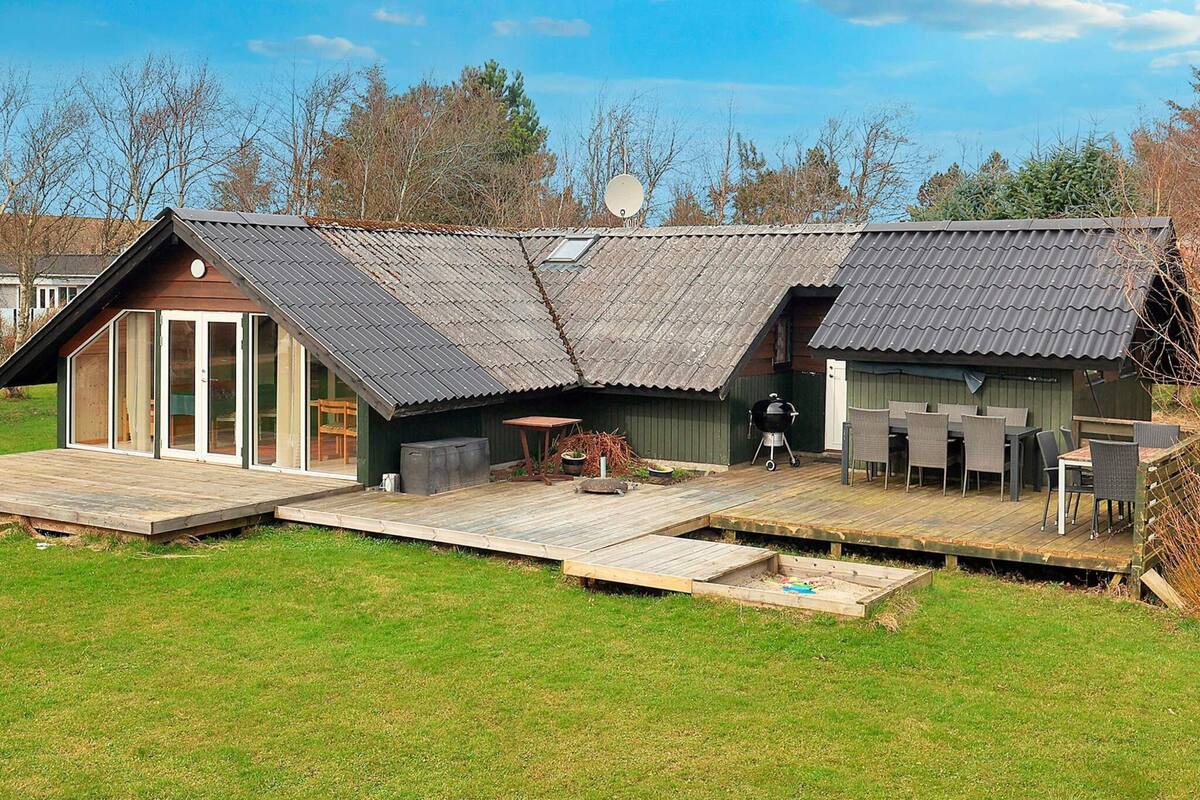 A house with a large deck, a barbecue area, and a satellite dish.