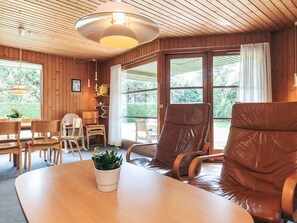 Un interior de madera con una mesa de comedor, sillas y un sofá.