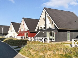 A row of modern beach houses with sloped roofs, white railings, and a clear sky. - Holiday Home in Wendtorf (Wendtorf)