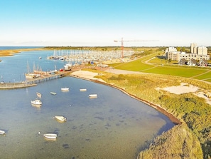 A marina with boats docked, a pier, and a construction crane in the background. - Holiday Home in Wendtorf (Wendtorf)