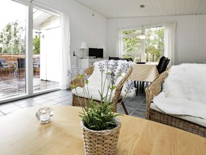 Relax in a welcoming space with a wooden table, wicker chairs, and a comfortable seating area.