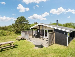 Eine Hütte mit einer überdachten Terrasse, einem Kamin und einem Schild mit der Nummer 1.