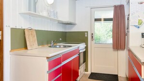 Una cocina compacta con un lavamanos, una estufa y una ventana.