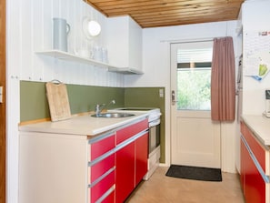 Eine kleine Küche mit Spüle, Herd und Fenster.