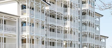 A multi-story building with balconies, a flat roof, and a clear sky.