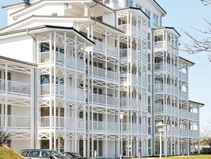 Un edificio de varios pisos con balcones, techo plano y cielo despejado.