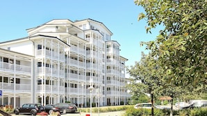 A multi-story hotel with balconies, a parking area, and a well-maintained lawn. - Holiday Home in Grossenbrode (Grossenbrode)