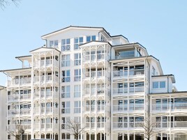 Un edificio de varios pisos con balcones y ventanas amplias.