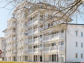 Un edificio de varios pisos con balcones y fachada blanca.