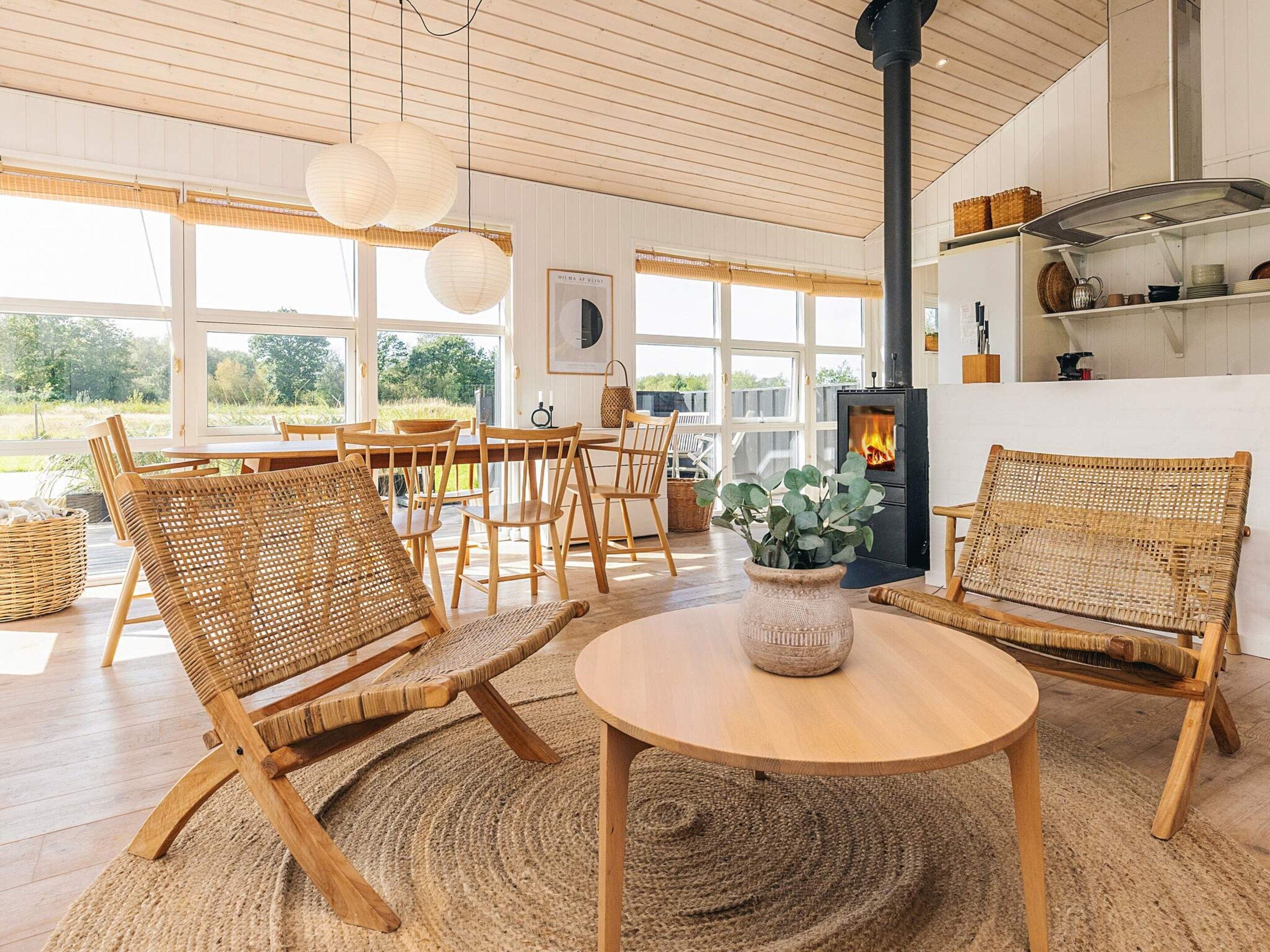 A cozy room with wicker furniture, a round table, and a fireplace.